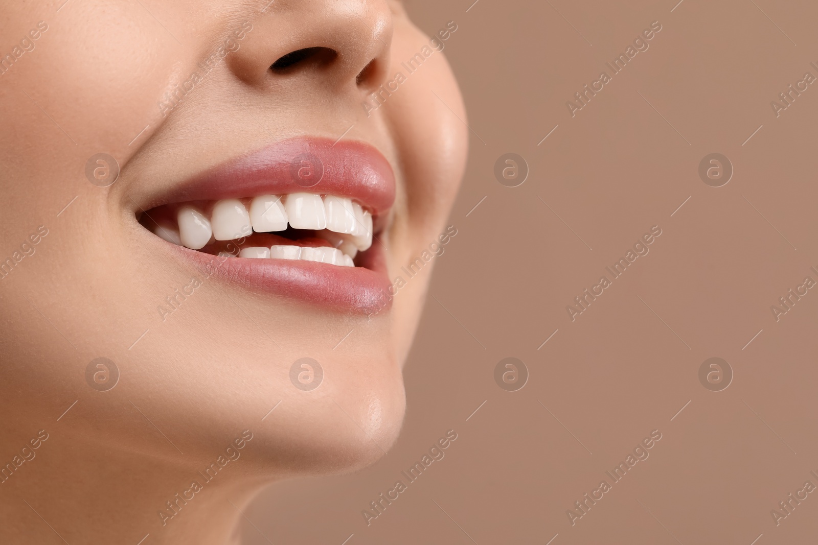 Photo of Woman with clean teeth smiling on beige background, closeup. Space for text