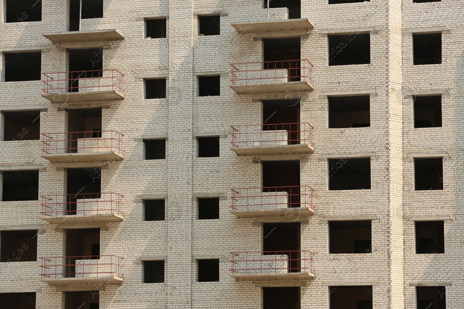 Photo of Unfinished white brick multistory building as background