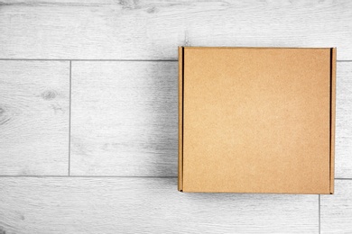 Photo of Closed cardboard box on wooden floor