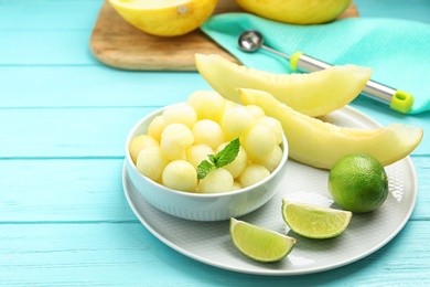 Melon balls with mint and lime on light blue wooden table