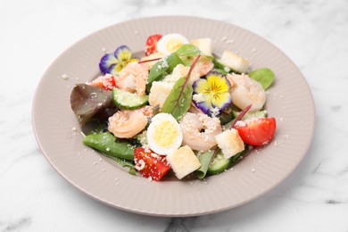 Delicious Caesar salad with shrimps on white marble table, closeup