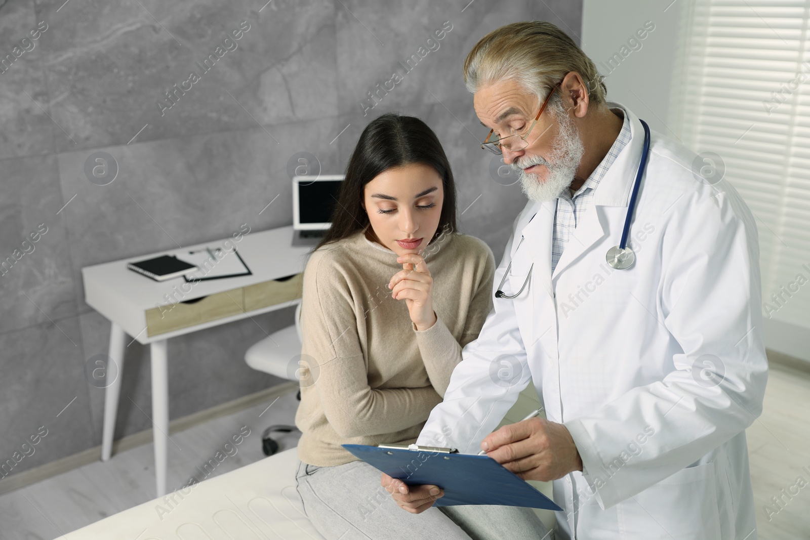 Photo of Patient having appointment with senior doctor in clinic