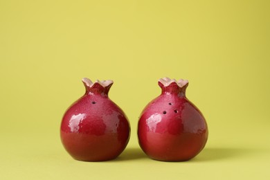 Pomegranate shaped salt and pepper shakers on yellow background