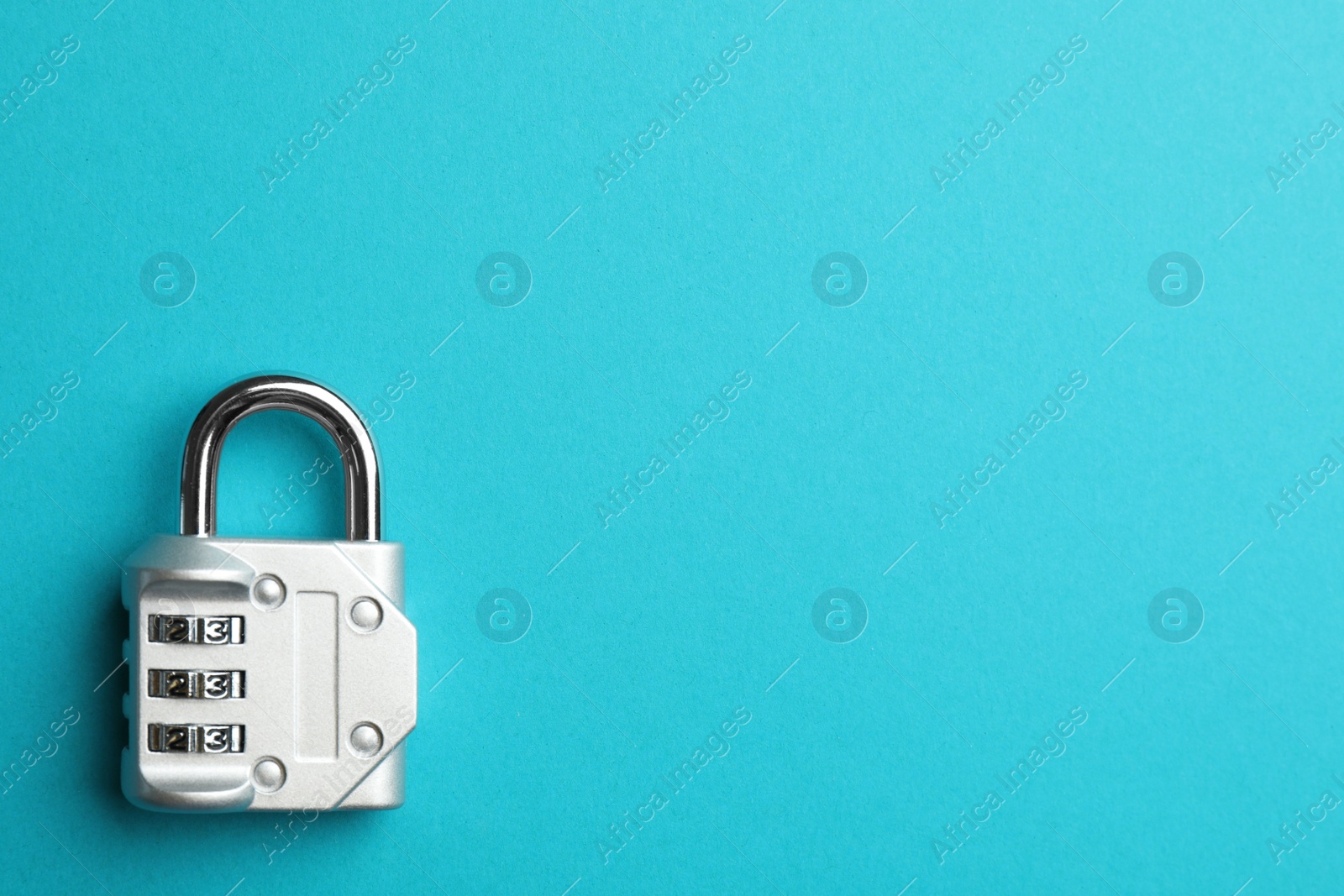 Photo of Modern combination lock on light blue background, top view. Space for text