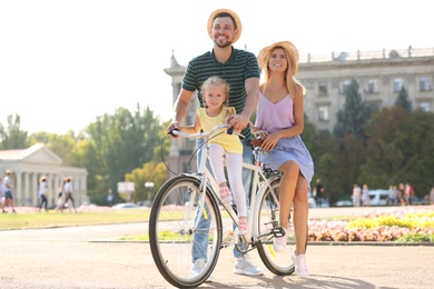 Happy family with bicycle outdoors on summer day