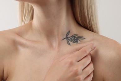 Photo of Woman with cool tattoo on light background, closeup