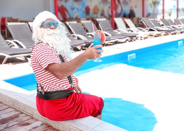 Authentic Santa Claus with cocktail near pool at resort