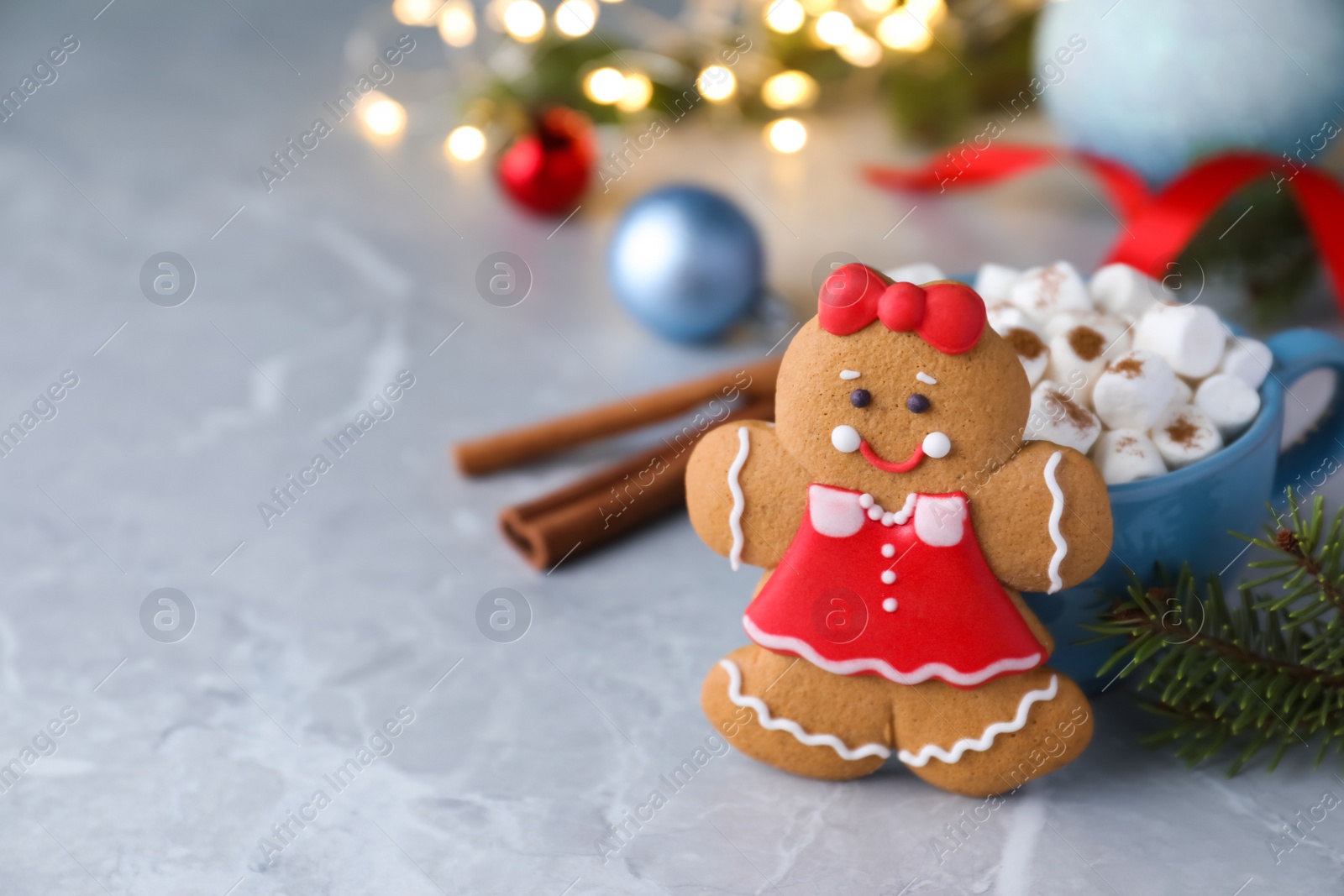 Photo of Gingerbread girl on grey marble table. Space for text