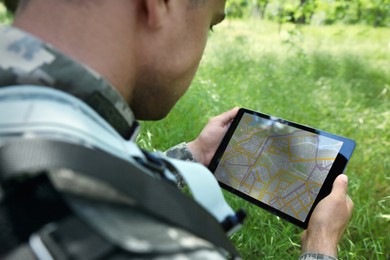 Photo of Soldier using tablet in forest, closeup view