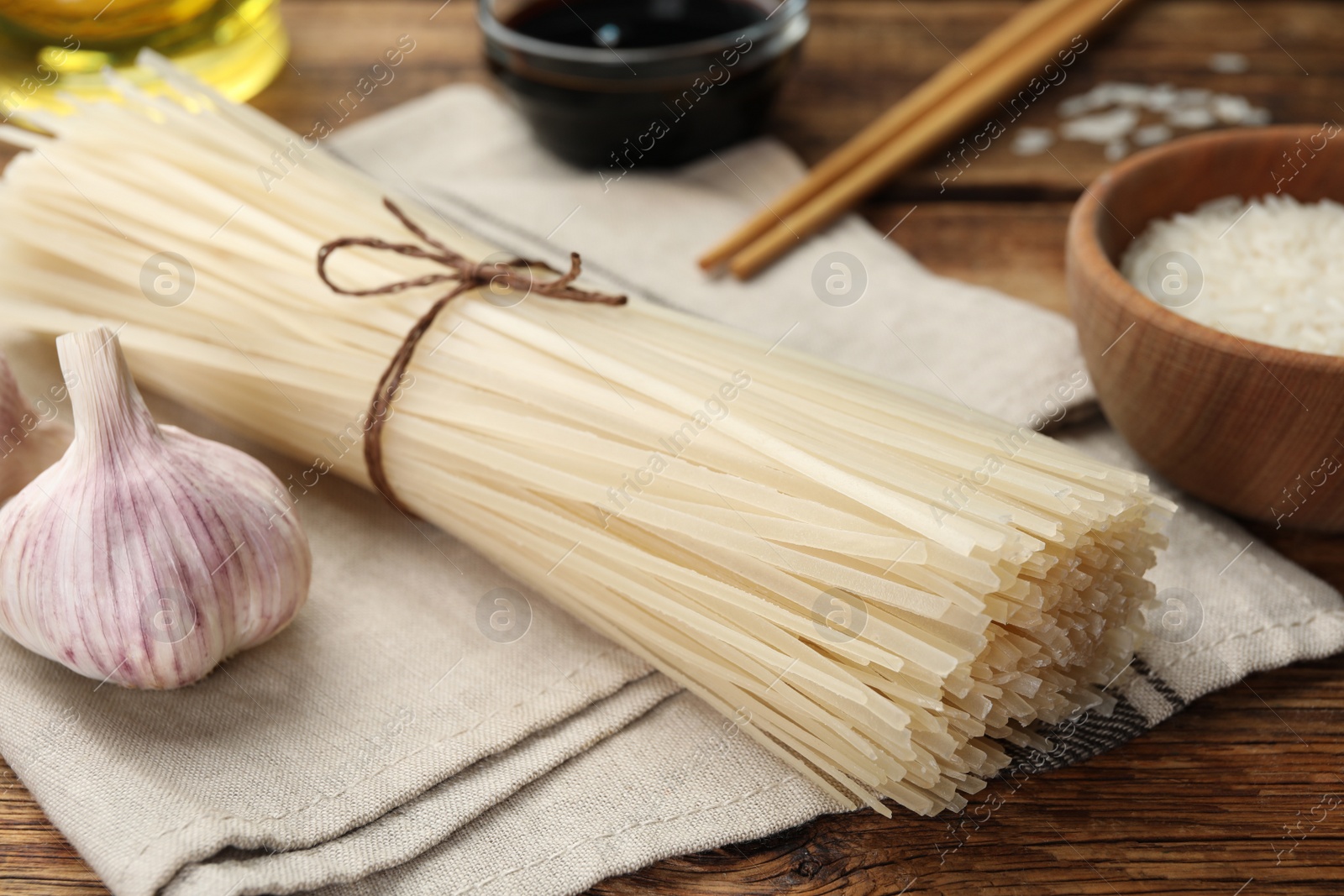 Photo of Uncooked rice noodles on wooden table, closeup