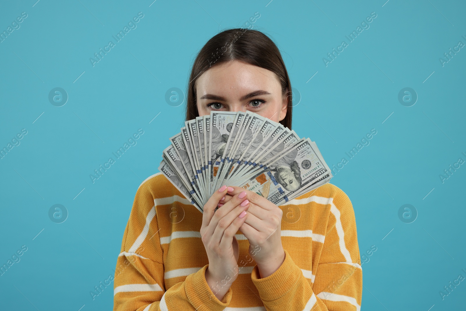 Photo of Woman with dollar banknotes on light blue background