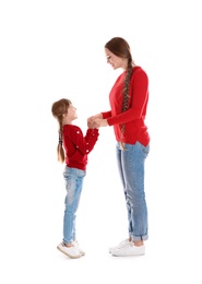 Happy woman and daughter in stylish clothes on white background