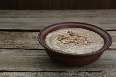 Delicious mushroom cream soup on wooden table. Space for text