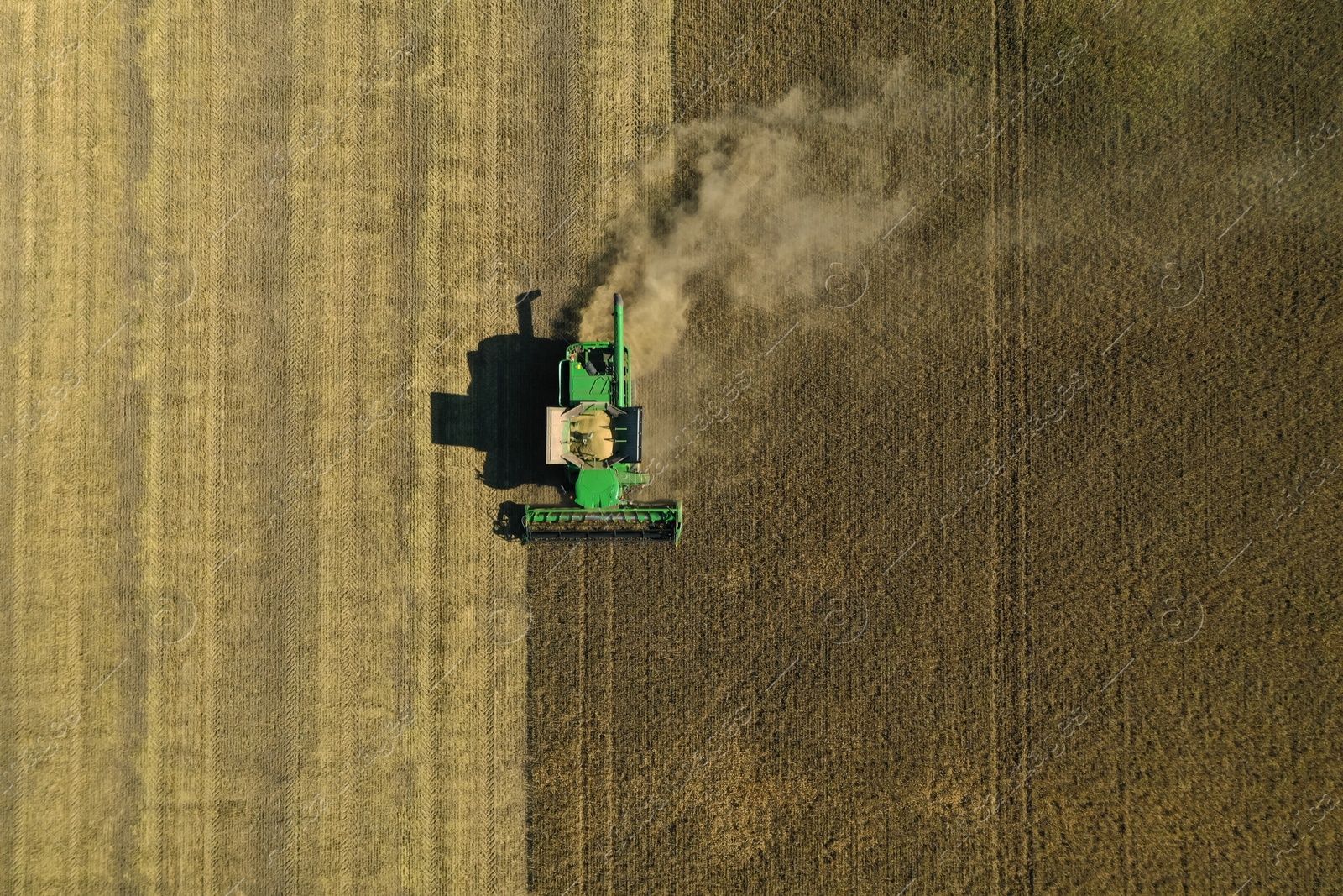 Photo of Beautiful aerial view of modern combine harvester working in field on sunny day. Agriculture industry