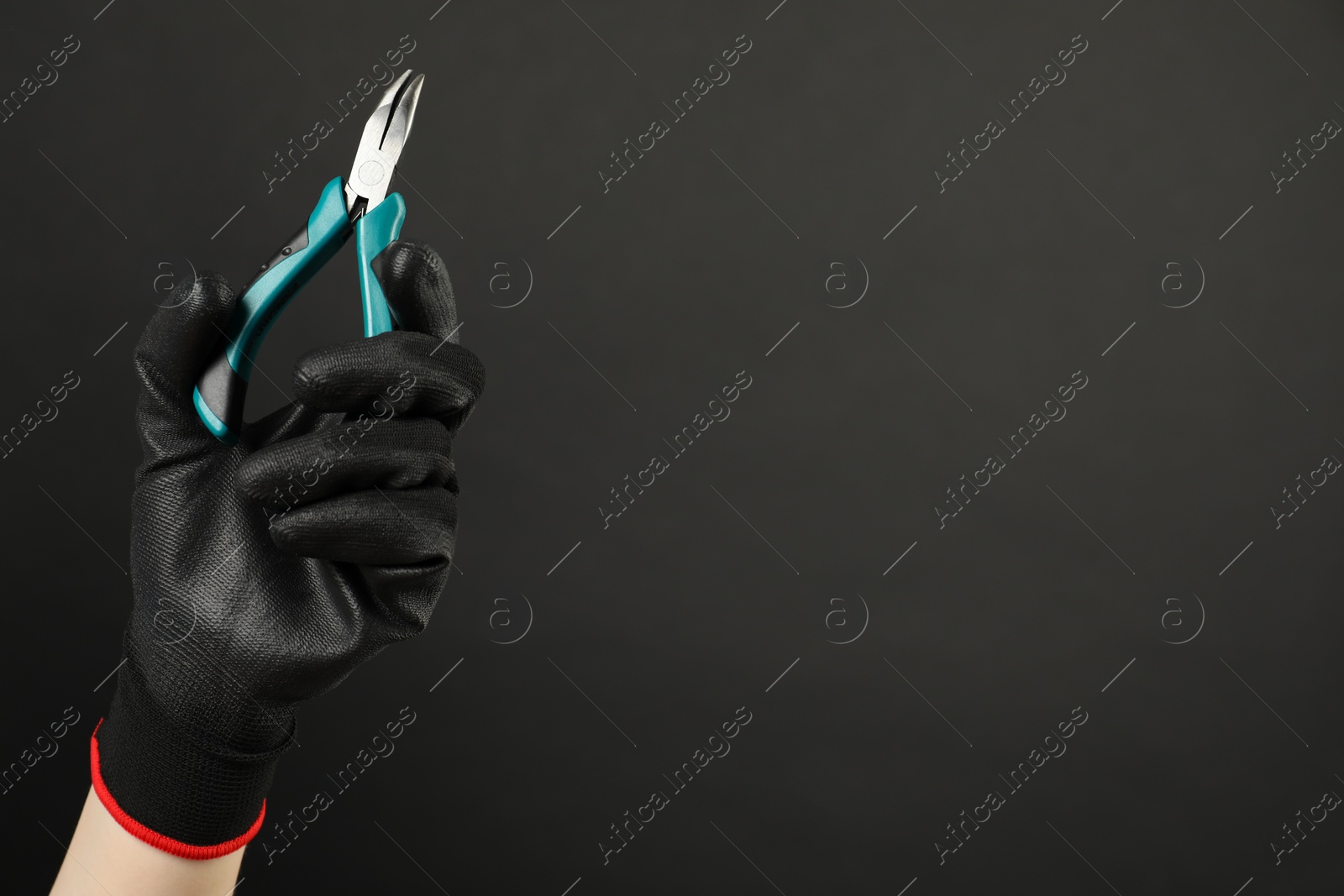 Photo of Woman with bent nose pliers on dark background, closeup. Space for text