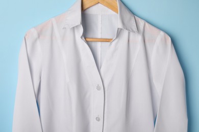 Photo of White medical uniform on light blue background