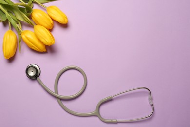 Photo of Stethoscope and yellow tulips on violet background, flat lay with space for text. Happy Doctor's Day