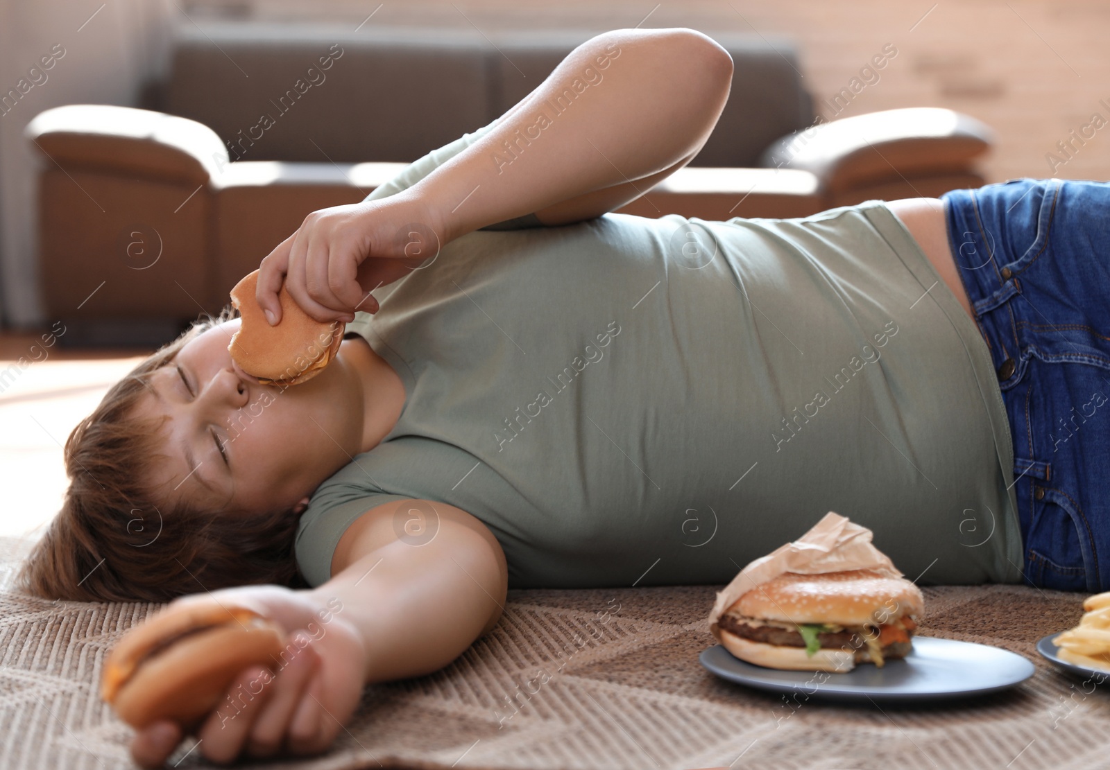 Photo of Overweight boy with fast food at home