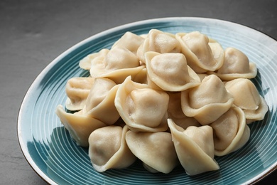 Photo of Tasty dumplings on blue plate, closeup view