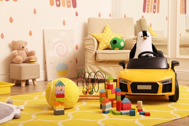 Child's electric car and other toys in playroom