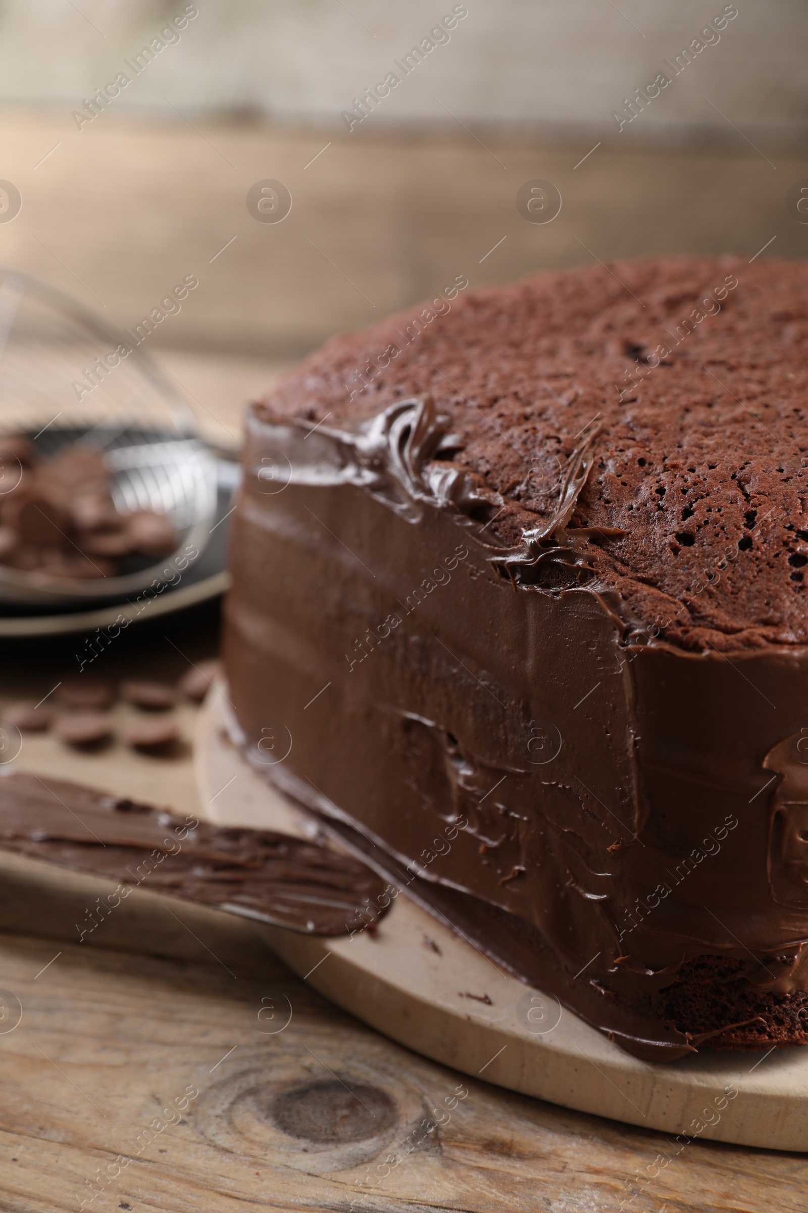 Photo of Delicious homemade layer cake with chocolate cream on wooden table, closeup