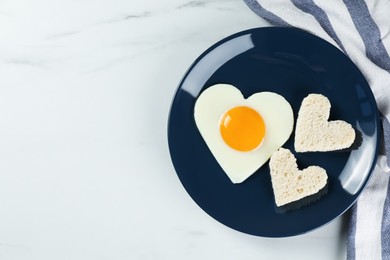 Photo of Romantic breakfast with heart shaped fried egg and toasts on white marble table, flat lay. Space for text
