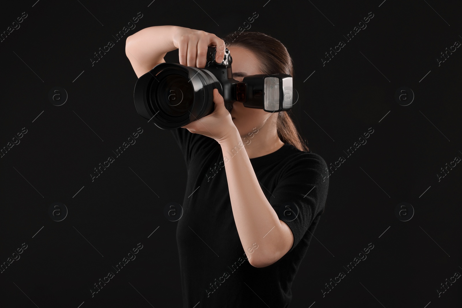 Photo of Professional photographer taking picture on black background