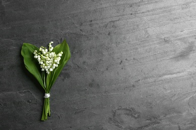 Beautiful lily of the valley bouquet on grey background, top view. Space for text