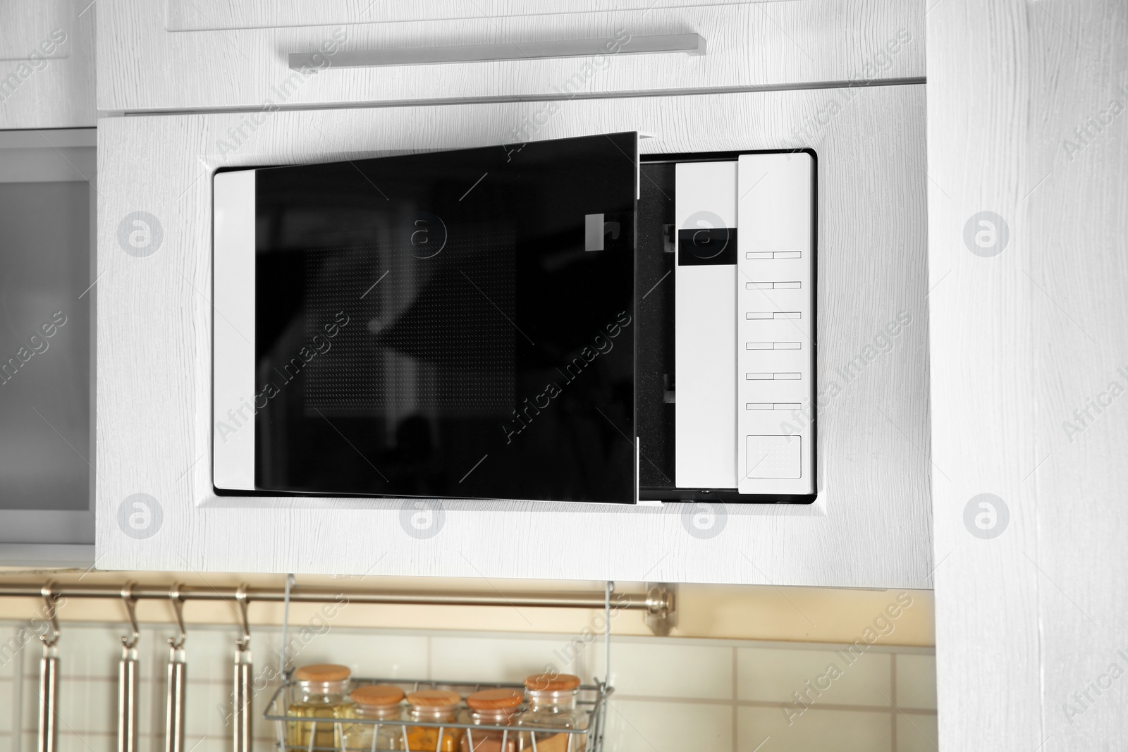 Photo of Open modern microwave oven built in kitchen furniture