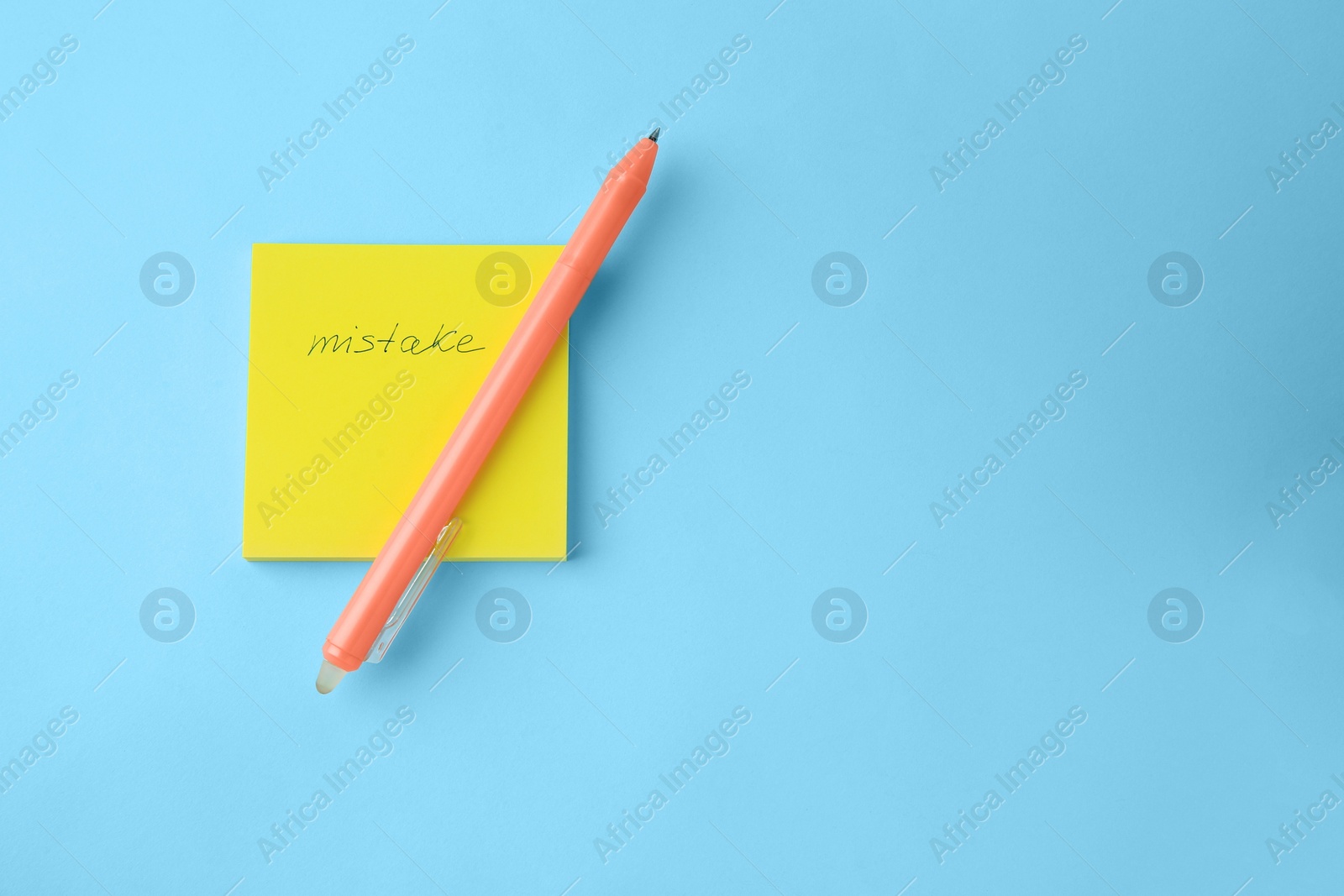 Photo of Paper notes with word Mistake and erasable pen on light blue background, top view. Space for text