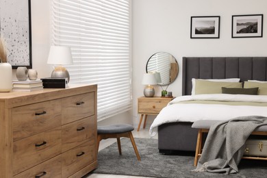 Photo of Window with horizontal blinds and comfortable bed in room