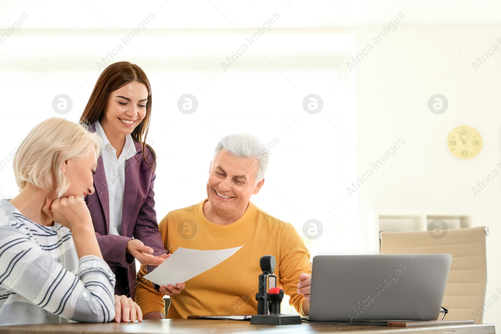 Photo of Female notary working with mature couple in office