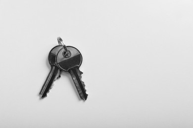 Photo of Keys on white background, top view and space for text. Real estate agent services