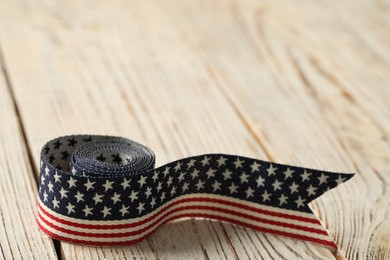 Ribbon with American flag pattern on white wooden table, closeup and space for text. Memorial Day