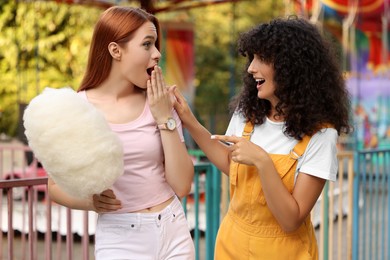 Photo of Happy friends with cotton candy spending time together at funfair