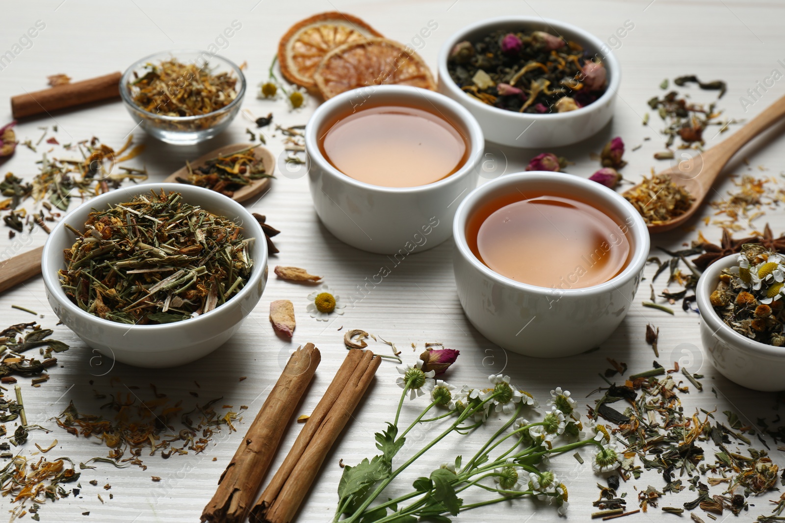 Photo of Fresh brewed tea and dry leaves on wooden table