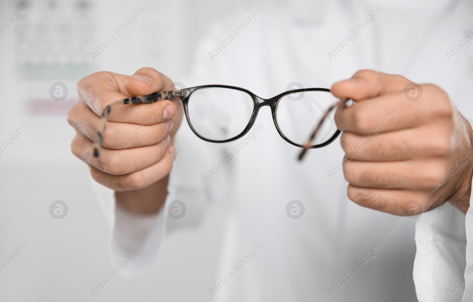 Photo of Male ophthalmologist with eyeglasses in clinic, closeup