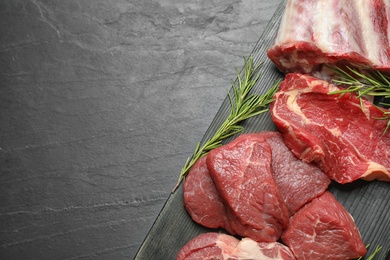 Photo of Fresh meat on black table, top view. Space for text