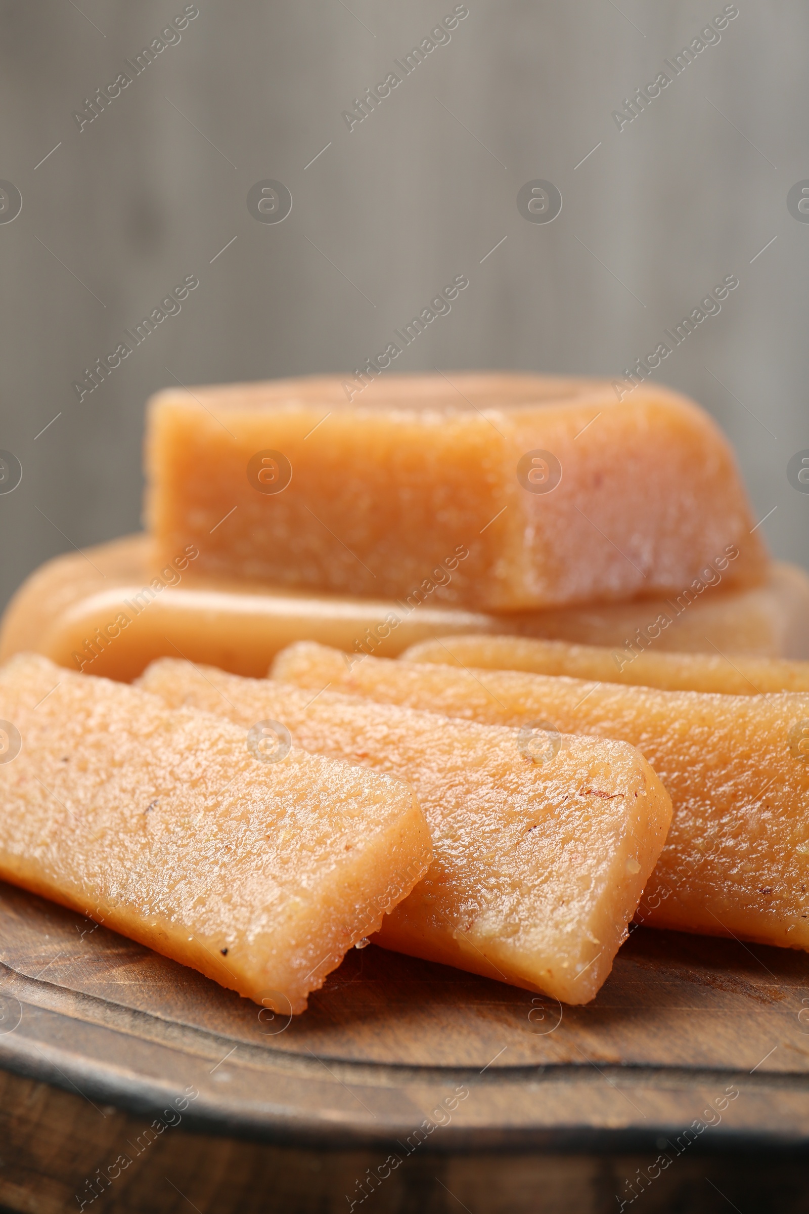 Photo of Tasty sweet quince paste on wooden board, closeup