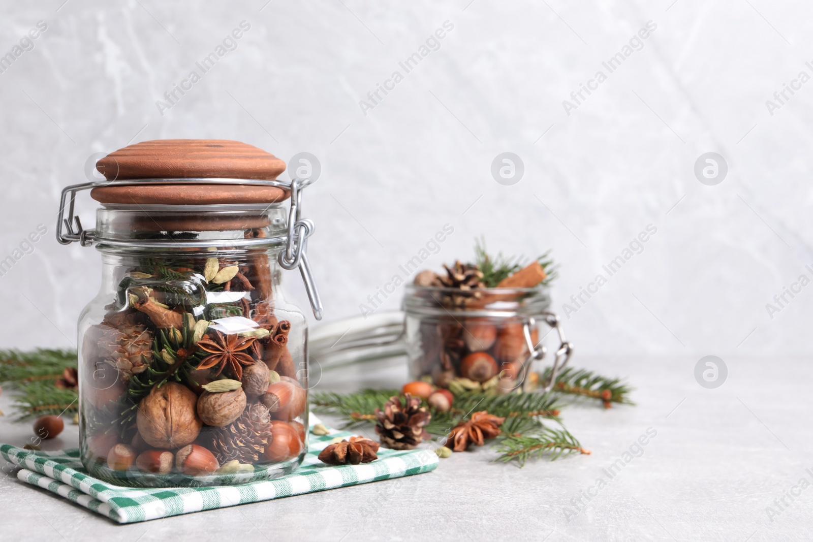 Photo of Aromatic potpourri in glass jar on white table. Space for text