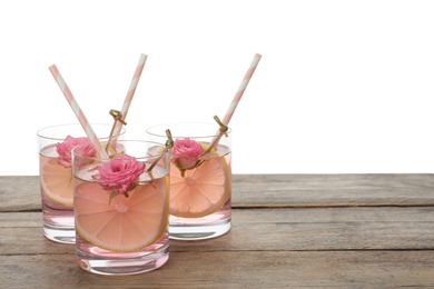 Refreshing drink with lemon and rose on wooden table