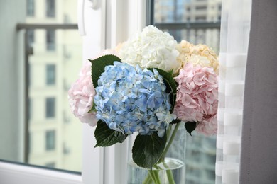 Photo of Beautiful hydrangea flowers in vase near window, closeup