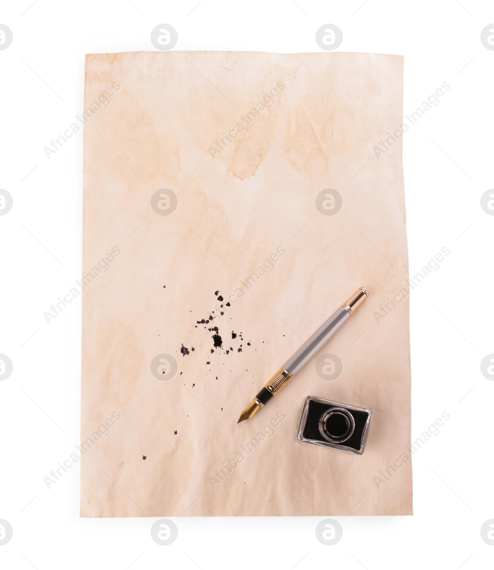 Photo of Parchment with stains of ink, fountain pen and inkwell on white background, top view