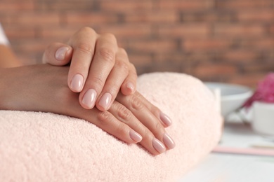 Photo of Woman showing neat manicure on towel, closeup with space for text. Spa treatment
