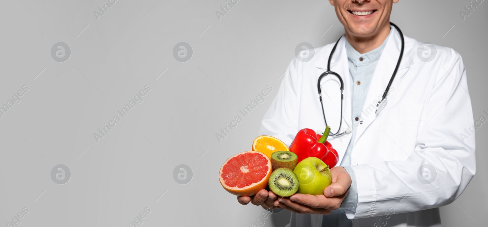 Image of Nutritionist with fresh products on light grey background, closeup view with space for text. Banner design