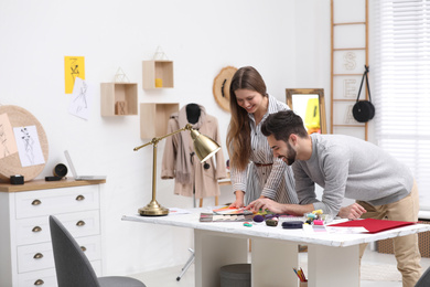 Fashion designers creating new clothes in studio