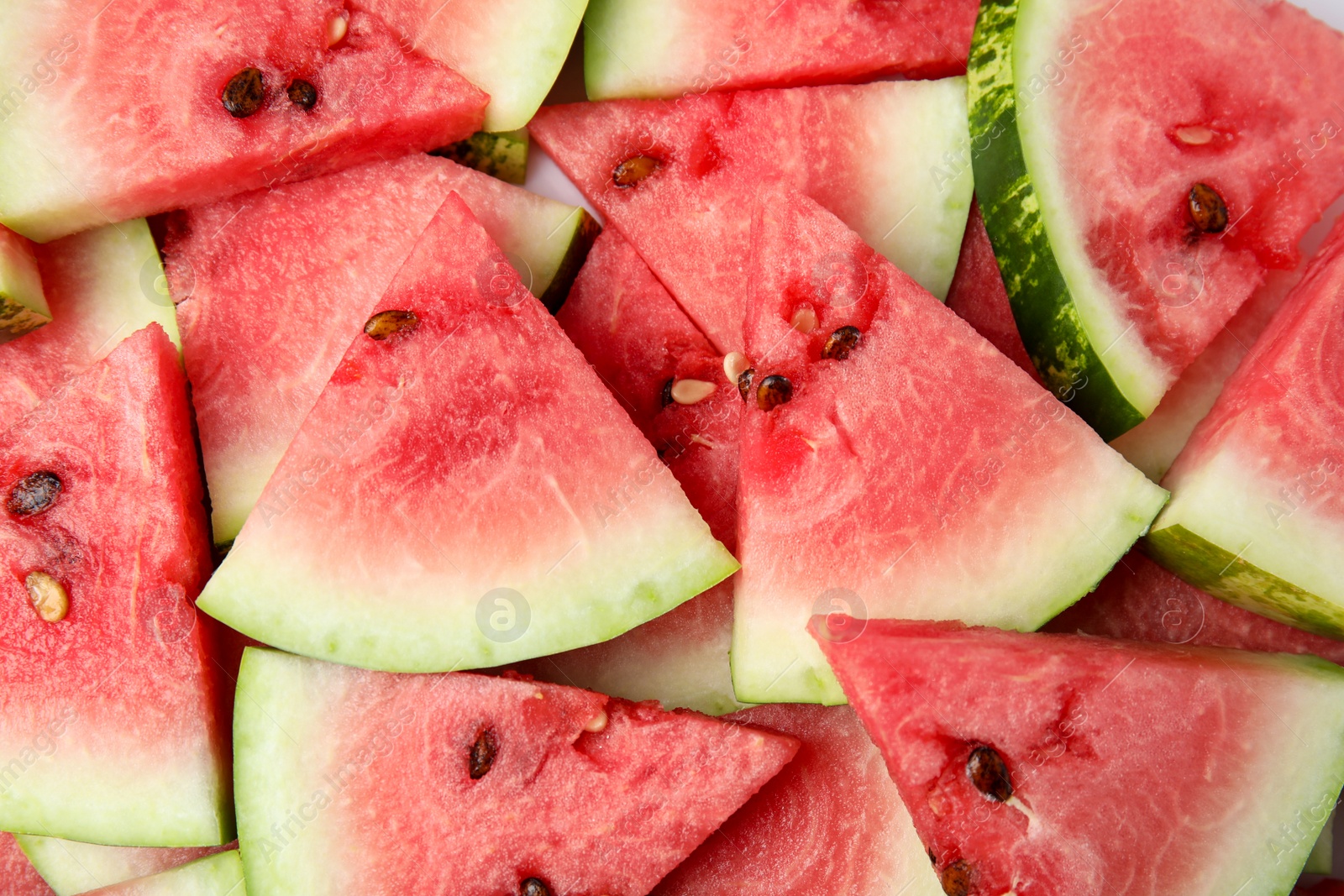 Photo of Many watermelon slices as background, top view