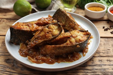 Tasty Indian fish curry on wooden table, closeup