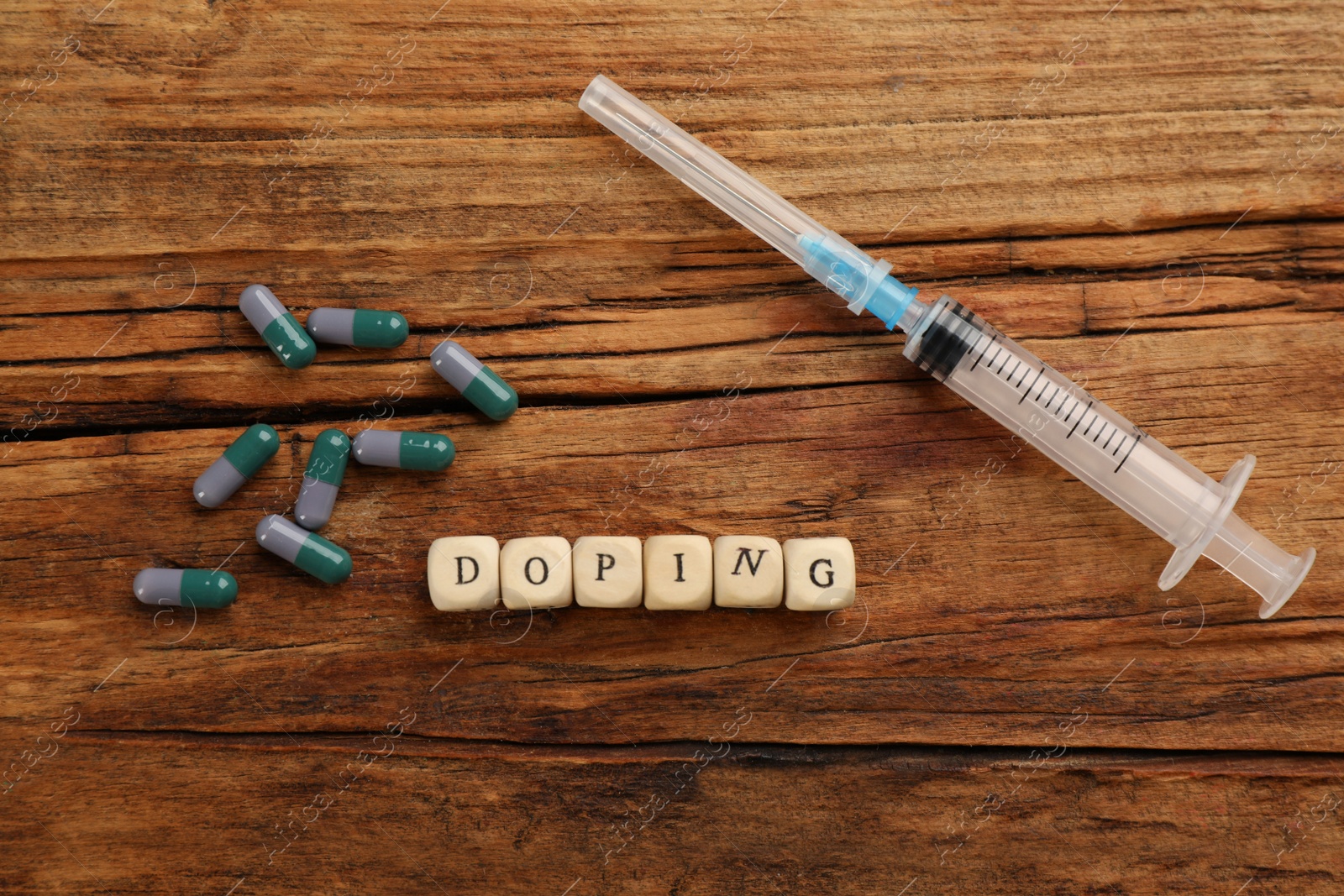 Photo of Cubes with word Doping and drugs on wooden background, flat lay