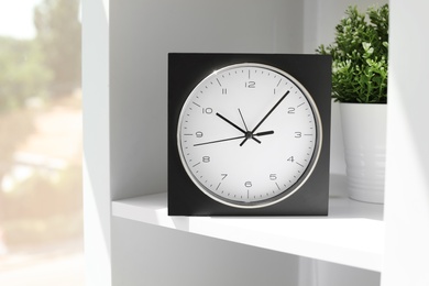 Analog clock on shelf indoors. Time of day